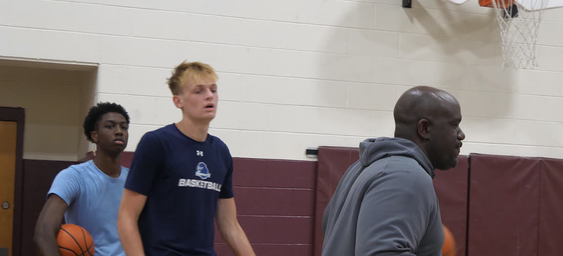Baseline Hoops coach with high school players in the gym