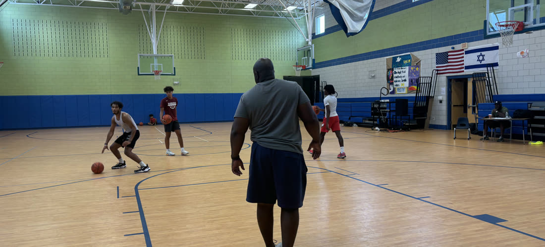 Coach watching players run a dribbling drill at Baseline Hoops group training
