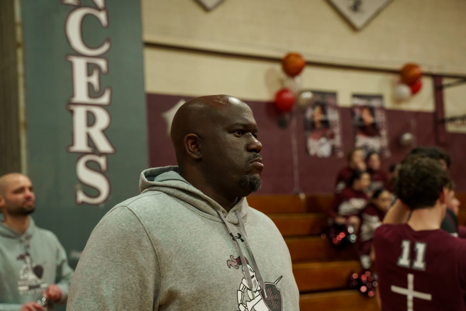 Baseline Hoops coach watching from the sideline at a high school game